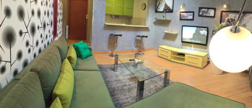 a living room with a green couch and a tv at Vip apartment Beograd in Belgrade