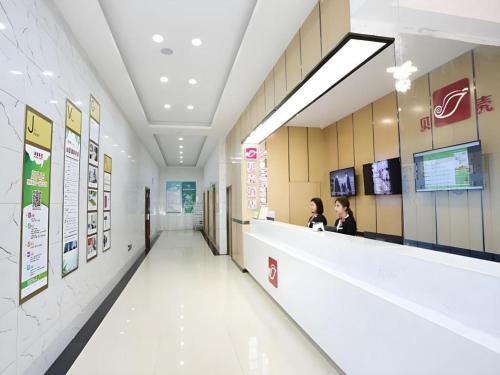 deux femmes assises à un comptoir dans le hall d'un hôpital dans l'établissement Shell Taiyuan South Station Shanxi University Hotel, à Taiyuan