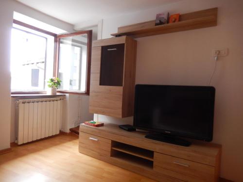 a living room with a flat screen tv on a wooden stand at Stole Apartment in Izola