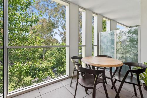 a table and chairs in a room with windows at Chic 2-Bed with Free Parking in South Yarra in Melbourne