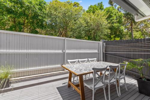 a patio with a table and chairs on a wooden deck at Relaxing 2-Bed Home Close to Beaches and Parks in Sydney