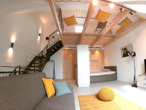 Una sala de estar con un sofá y una escalera. en miniLOFT apartments Linz, en Linz