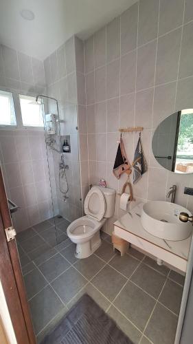 Un baño con inodoro, ducha y lavabo. en Season to table, en Ban Cho Lae