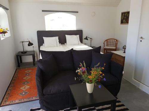 a living room with a couch and a table with flowers at Bästekille Gårdshotell in Kivik