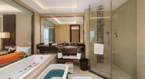 une grande salle de bain avec une baignoire et un lavabo dans l'établissement Howard Johnson Zunyue Hotel Chengdu, à Chengdu