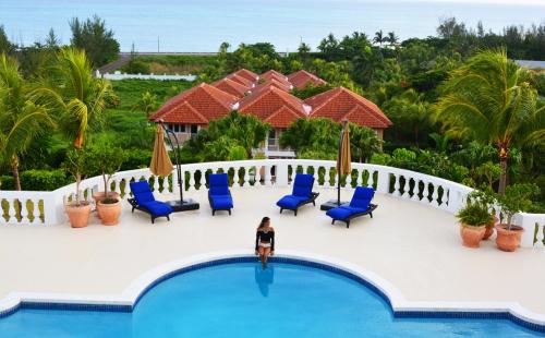 a woman standing on the edge of a swimming pool at a resort at Ocean West Boutique Hotel in Nassau