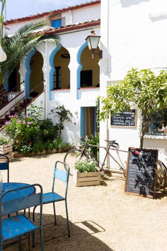 a building with two chairs and a sign in front of it at Hostal l'Estrella in Palafrugell