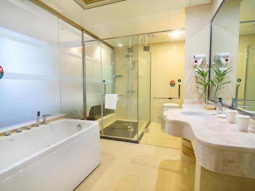 ein Badezimmer mit zwei Waschbecken und einer Dusche in der Unterkunft GreenTree Inn Jiangsu Wuxi Xishan DongTing Erquan East Road XinGuang Newly Estate Express Hotel in Wuxi