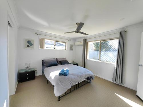 ein Schlafzimmer mit einem Bett und zwei Fenstern in der Unterkunft Stylish Cosy Retreat in North Lakes all Air-Con in North Lakes