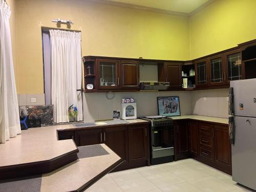 キャンディにあるSky rise mount hotelの木製のキャビネットと白い冷蔵庫を備えたキッチン