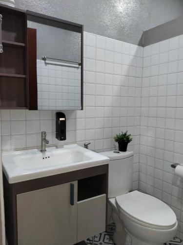 a bathroom with a sink and a toilet at Emman's Guest House in Anda