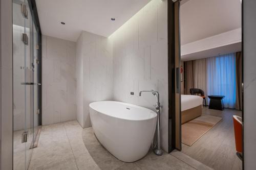 武汉武汉江汉路丽芮酒店的卧室浴室设有白色浴缸