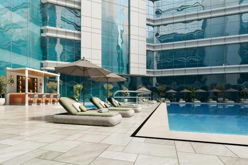 an exterior view of a building with a swimming pool at Vintage Grand Hotel Apartments Dubai in Dubai