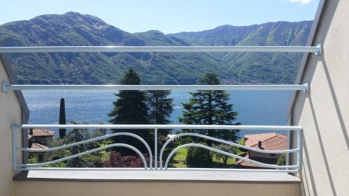 a window with a view of a lake and mountains at Hotel Lario in Mezzegra