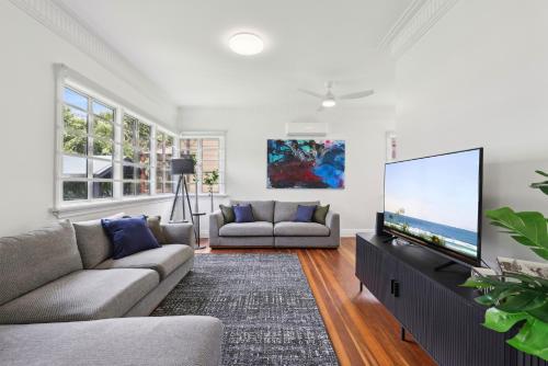 a living room with a couch and a flat screen tv at Spacious 3-Bed Home in Morningside with Backyard in Brisbane