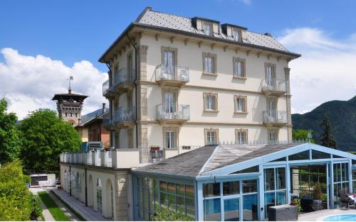 a large white building with a clock tower at Hotel Lario in Mezzegra