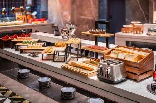 uma linha de bufê com diferentes tipos de comida em exposição em Radisson RED Wuhan Jianghan Road em Wuhan