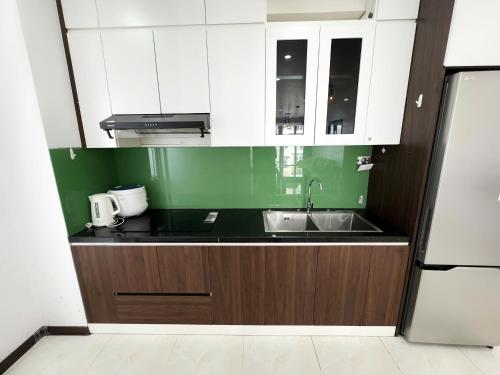 a kitchen with white cabinets and a sink at Bai Chay Apartment in Ha Long