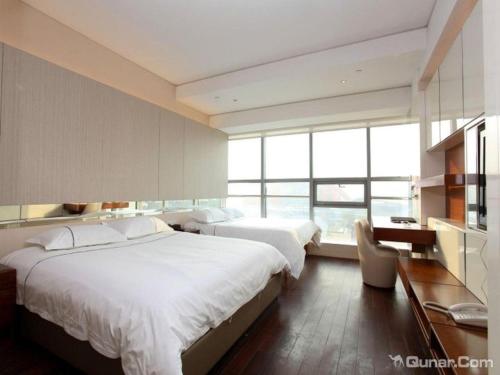 une chambre d'hôtel avec deux lits, un bureau et des fenêtres dans l'établissement Nanjing YuTimes Hotel, à Nankin