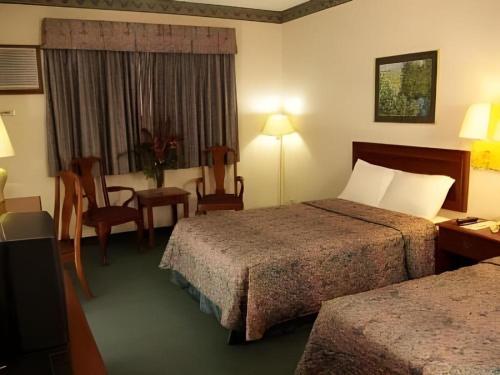 a hotel room with two beds and a table and chairs at Batangas in Dilao