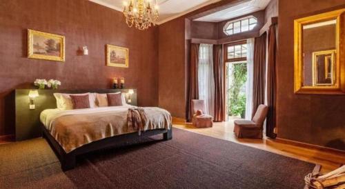 a bedroom with a large bed and a chandelier at Craigbank Nuwaraeliya in Nuwara Eliya