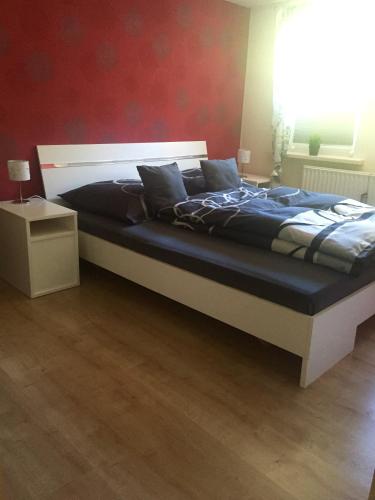 a large bed in a bedroom with a red wall at Lillys Ferienhaus in Sankt Andreasberg