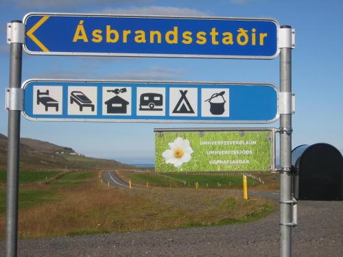 a blue street sign with a sign for a handicapped at Ásbrandsstadir Cottages in Vopnafjörður