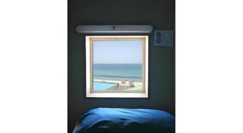 ein Fenster in einem Schlafzimmer mit Meerblick in der Unterkunft Capsule Inn Gangneung in Kangmun