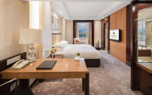 une chambre d'hôtel avec un lit et un bureau avec un ordinateur dans l'établissement New Century Shaoxing Grand Hotel, à Shaoxing