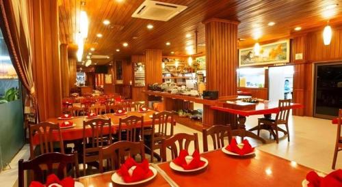 ein Restaurant mit Tischen und Stühlen und eine Bar in der Unterkunft Asia Hotel in Phnom Penh