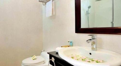 a bathroom with a sink and a toilet and a mirror at Sa Huynh Resort Quang Ngai in Sa Huynh