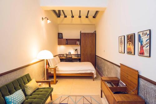 un soggiorno con divano e letto di OrigInn Space a Taipei