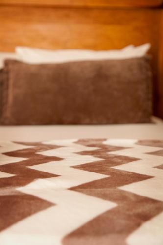 a bed with a brown and white pattern on the floor at Welgerust Bed & Breakfast in Piet Retief