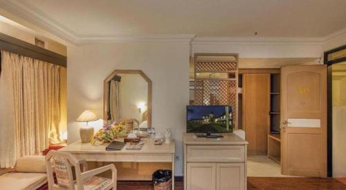 un salon avec un bureau avec un ordinateur dedans dans l'établissement eL Hotel Kartika Wijaya Batu, à Songgoriti