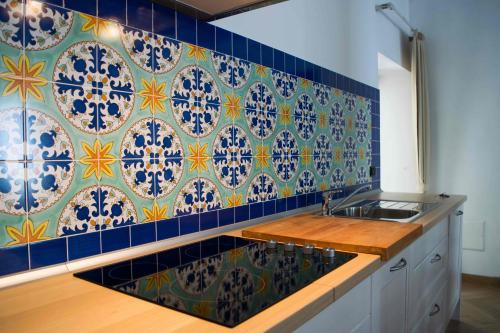 a kitchen with blue and yellow tiles on the wall at Monasterace 288 in Marina di Monasterace