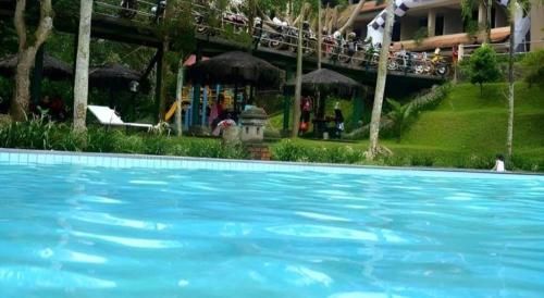 ein großer blauer Pool vor einem Hotel in der Unterkunft Augusta Hotel & Glamping Sukabumi in Jambatan