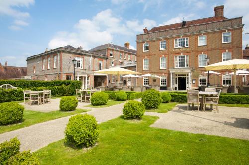 ブランドフォード・フォーラムにあるThe Crown Hotelの建物の前にテーブルと傘