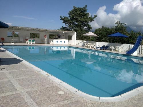 a large blue swimming pool with a water slide at Hotel Villa Amparo in Chinauta