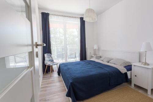 コウォブジェクにあるApartament SunSeaのベッドルーム(青いベッド1台、窓付)