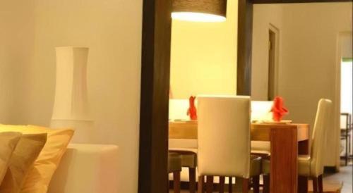 une salle à manger avec une table et des chaises blanches dans l'établissement 26 Loversleap Cottage, à Nuwara Eliya