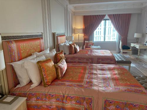 Habitación de hotel con 3 camas y almohadas coloridas en 澳门公关特价酒店, en Macau