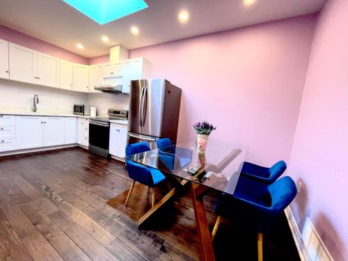 a kitchen with a glass table and blue chairs at Quiet King Bedroom near DT Toronto in Toronto