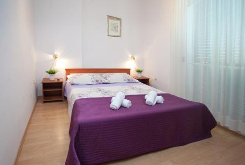 a bedroom with a bed with two stuffed animals on it at Bačvice beach apartment in Split