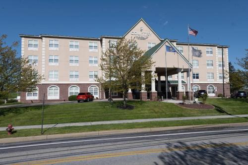 a building with an american flag in front of it at Country Inn & Suites by Radisson, Harrisburg - Hershey West, PA in Harrisburg