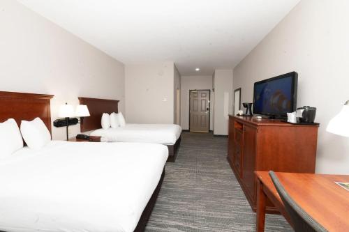 a hotel room with two beds and a flat screen tv at Country Inn & Suites by Radisson, Harrisburg - Hershey West, PA in Harrisburg