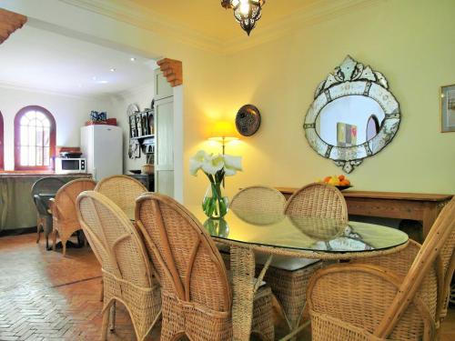 a dining room with a table with chairs and a mirror at Christina's House in Asilah