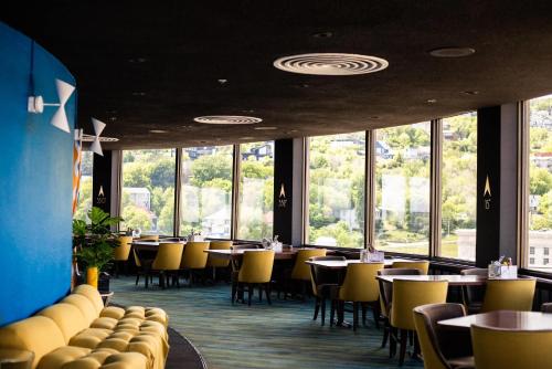 a dining room with tables and chairs and windows at Radisson Hotel Duluth-Harborview in Duluth