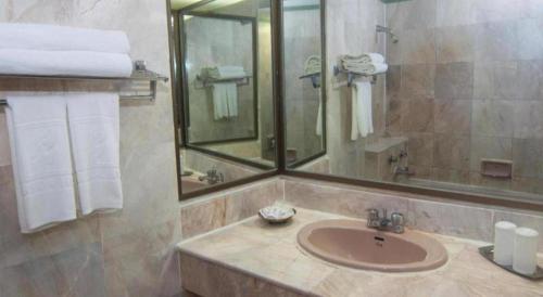 a bathroom with a sink and a mirror and towels at Florida Hotel in Hat Yai