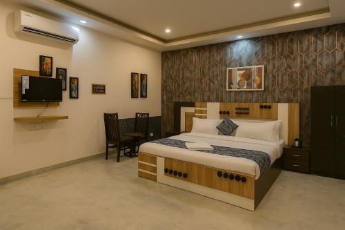 a bedroom with a bed and a flat screen tv at Hotel Kasol Heritage in Lucknow