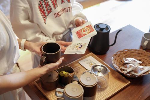 a couple of people holding coffee cups on a table at Temari Inn Madoromi in Kurashiki